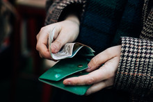 Woman Taking Out Money From Her Green Wallet