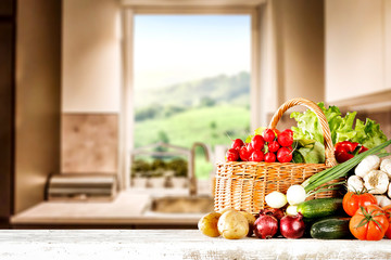 Wall Mural - Wooden desk cover of fresh vegetables and blurred kitchen interior with window 