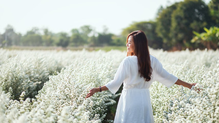 Wall Mural - Portrait image of an asian woman walking into a beautiful Cutter flower field