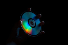 Compact-disc In Hand On A Black Background