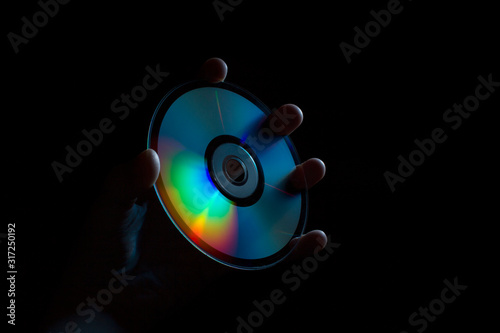 Fotografía compact-disc in hand on a black background