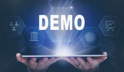 Businessman holding a computer tablet display projecting a Demo concept.
