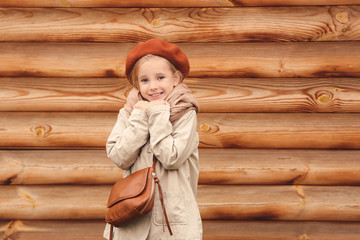 Sticker - Cute little girl in autumn near wooden wall outdoors