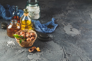 Natural macadamia oil in a glass bottle with macadamia nuts