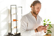 © Drobot Dean - Photo of businessman wearing white shirt holding cellphone in apartment