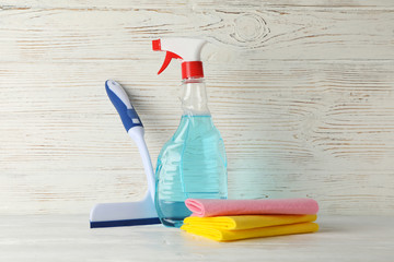 Detergent liquid and cleaning supplies on wooden background, space for text