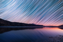Night Landscape. Beautiful Lake And Mountains At The Night. The Colorful Star Trails On The Sky. Night Timelapse Photography.
