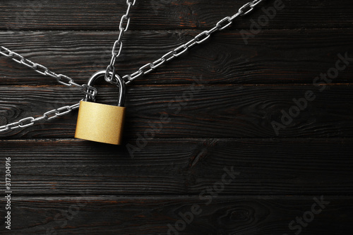 Steel padlock, chains and space for text on black wooden background, flat lay Poster Mural XXL