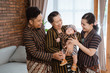 © Odua Images - having fun of asian happy family wearing javanese batik heritage with sleeping boy at house