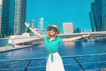 Wall Mural - Asian girl on a deck of cruise ship enjoying great view of skyscrapers of Marina port in Dubai