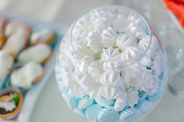 white and blue meringue in transparent vase on wedding candy bar