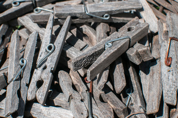 Pile of weathered wooden laundry clamps closeup in reed basket