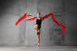 Girl on pointe with a red cloth on a gray background. The dancer is standing on one leg in a pose.girl, dance, dancer, ballet, ballerina, modern, pointe shoes, balance, power