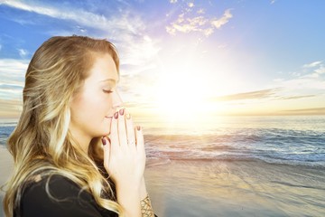 Poster - Side profile of a blonde woman praying with the sea on the background