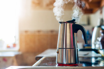 Geyser coffee maker on an electric stove in the kitchen in the morning