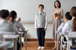 © Blue Jean Images - Young teacher introducing a new classmate in classroom