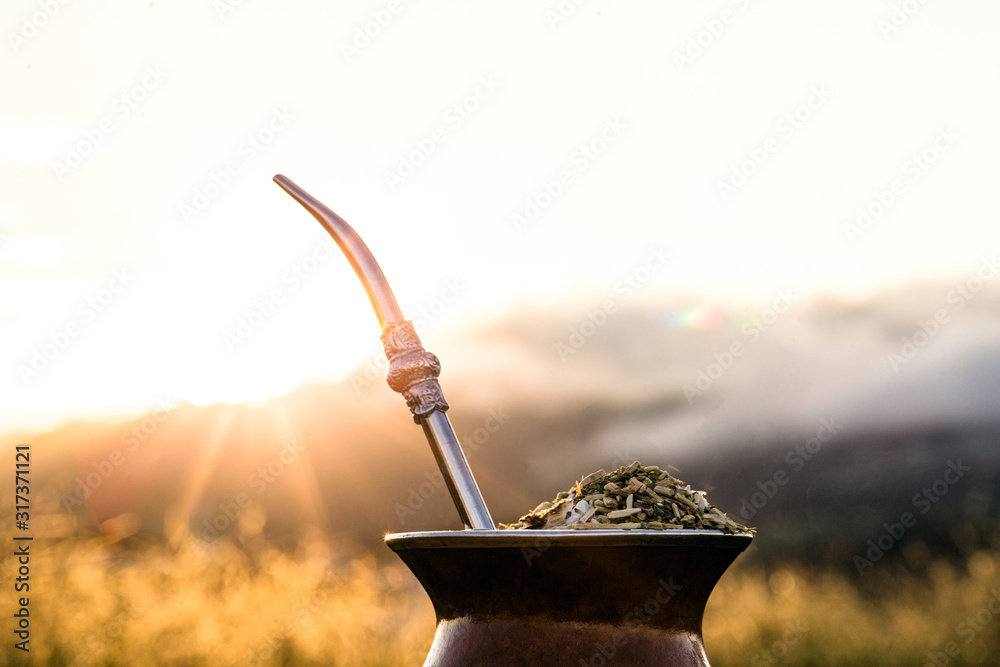 Chimarrão, or mate, is a characteristic drink of the culture of southern South America bequeathed by indigenous cultures. It consists of a gourd, a pump, ground yerba mate and warm water. - obrazy, fototapety, plakaty 