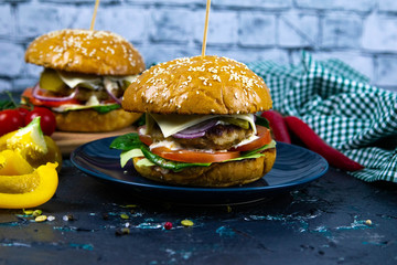 Two homemade beef burgers with mushrooms, micro greens, red onion on wooden cutting board