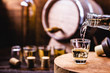 © RHJ - Glass of golden rum, with bottle. Bottle pouring alcohol into a small glass. Brazilian export type drink. Brazilian product for export, distilled drink known as brandy or pinga. Day of cachaça.