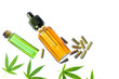 Glass bottles with Cannabis CBD oil, CBD pills and THC tincture and hemp leaves on white background