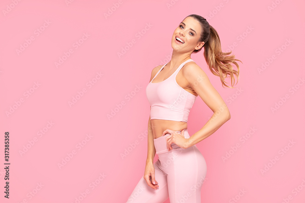 Smiling girl enjoying fitness training. - obrazy, fototapety, plakaty 