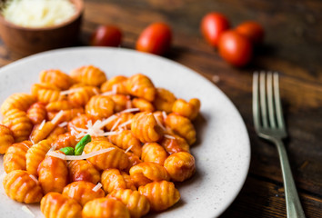 Wall Mural - Gnocchi with tomato sauce, basil, and cheese, traditional Italian pasta food made of potatoes and flour