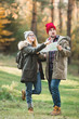 © zadorozhna - Travel couple with map, compass and backpack in the forest. Freedom and active travel concept.