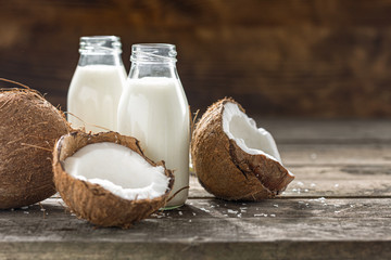 Wall Mural - Coconut kefir in glass bottle on wooden table. Vegan non dairy healthy or fermented drink. Healthy eating concept