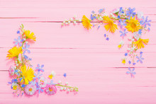 Frame Of Beautiful Flowers On Pink Wooden Background