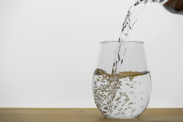 Motion blur of pouring pure drinking water flow into the glass making splash of clearly bubble