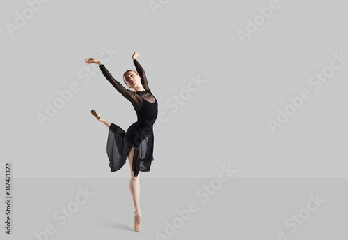 Cuadros en Lienzo Woman ballet dancer over gray background.