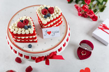 Romantic Present On St. Valentines Day. Two Cakes In Heart Shape, Roses Bouquet And A Gift Box With A Ring On Light Background. Selective Focus