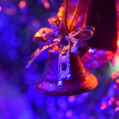Poster - toy bell on the background of bright festive lights, blurred image