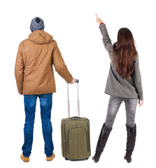 Poster - young couple in winter jacket traveling with suitcas.