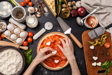 Classic pizza margherita with heart-shaped mazarella cheese. preparing a phased gala dinner for two at home in honor of Valentine's Day.