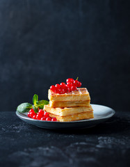 Wall Mural - Belgian waffles with fresh red currant berries. Dark slate background. Copy space.