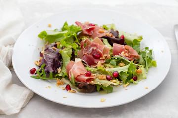 Wall Mural - salad prosciutto with pomegranate on white plate