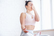 © Rithor - Side view of young healthy woman sitting in lotus mudra alternate nostril breathing exercise, nadi shodhana pranayama pose in spacious gym. Concept of breathing practice and meditation. Copyspace