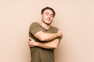 Young caucasian man posing isolated hugs, smiling carefree and happy.