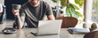 © Art_Photo - Handsome bearded hipster man use and looking at laptop computer with coffee at table in cafe.Communication and technology concept
