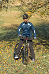 Cyclist in pants and fleece jacket on a modern carbon hardtail bike with an air suspension fork. The guy on the top of the hill rides a bike.