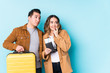© Asier - Young couple ready for a travel isolated relaxed thinking about something looking at a copy space.
