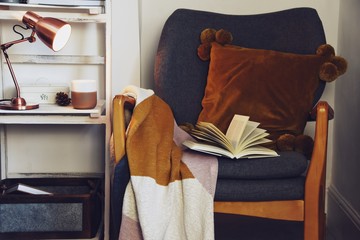 Cozy hygge interior with rocking chair, blanket and book