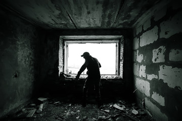 man against the background of a window in a ruined house, horror, fear concept, radiation stalker in Chernobyl zombie apocalypse