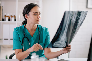 Female doctor with holding x-ray. Orthopedic doctor in medical office. 