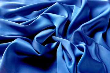 Blue sapphire color silk fabric background, top view.