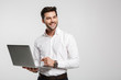 © Drobot Dean - Image of young cheerful businessman holding and using laptop