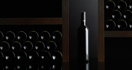 Red wine bottles on a black reflective background. Copy space.