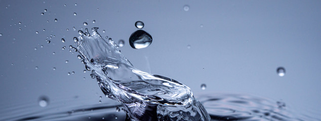 Wall Mural - water drops collision on a blue background. abstract clear nature background