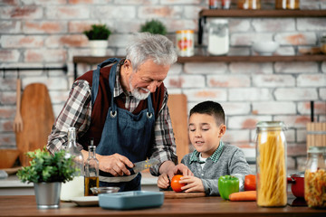 Wall Mural - Grandpa and grandson in kitchen. Grandfather and his grandchild having fun while cooking. 